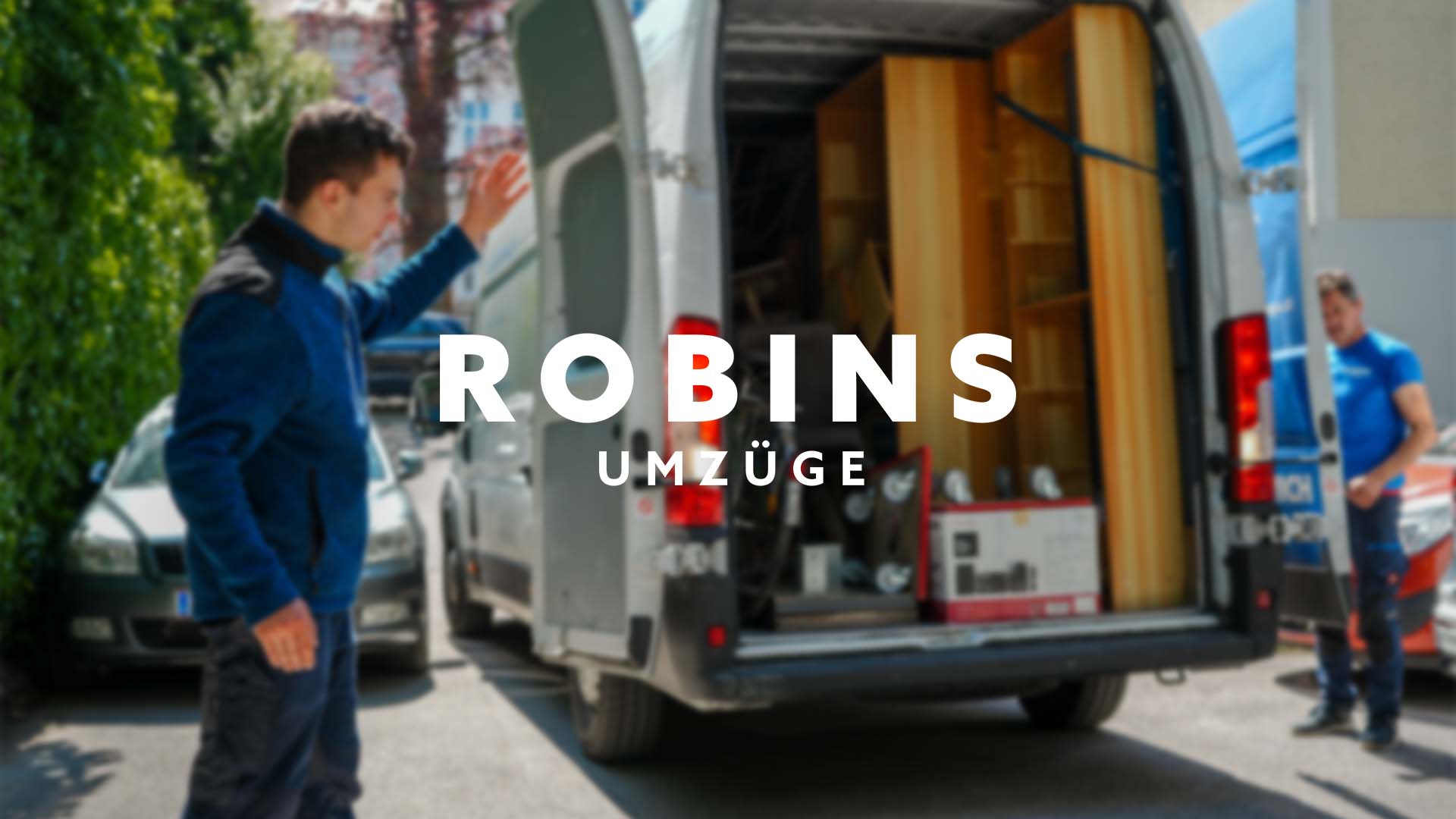 Eine Person deutet auf einen offenen Umzugswagen voller Möbel und Kisten, während eine andere neben dem Wagen steht. Der Text „Robins Umzüge“ ist prominent in der Bildmitte platziert und betont deren Umzugsservice.