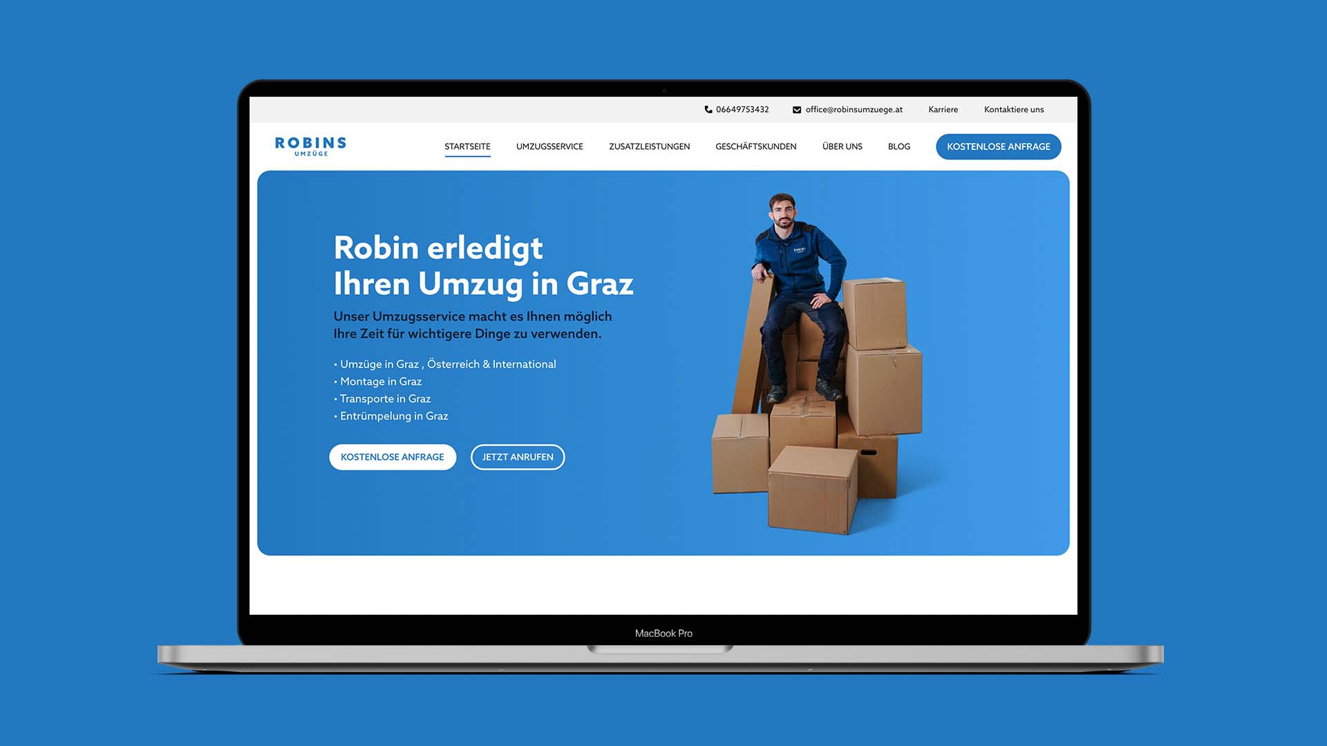 Auf einem Laptop-Bildschirm ist die Website „Robins Umzüge“ zu sehen, auf der eine Person auf mehreren Kartons sitzt. Der Text auf dem Bildschirm ist auf Deutsch und wirbt für Umzugsdienste in Graz.